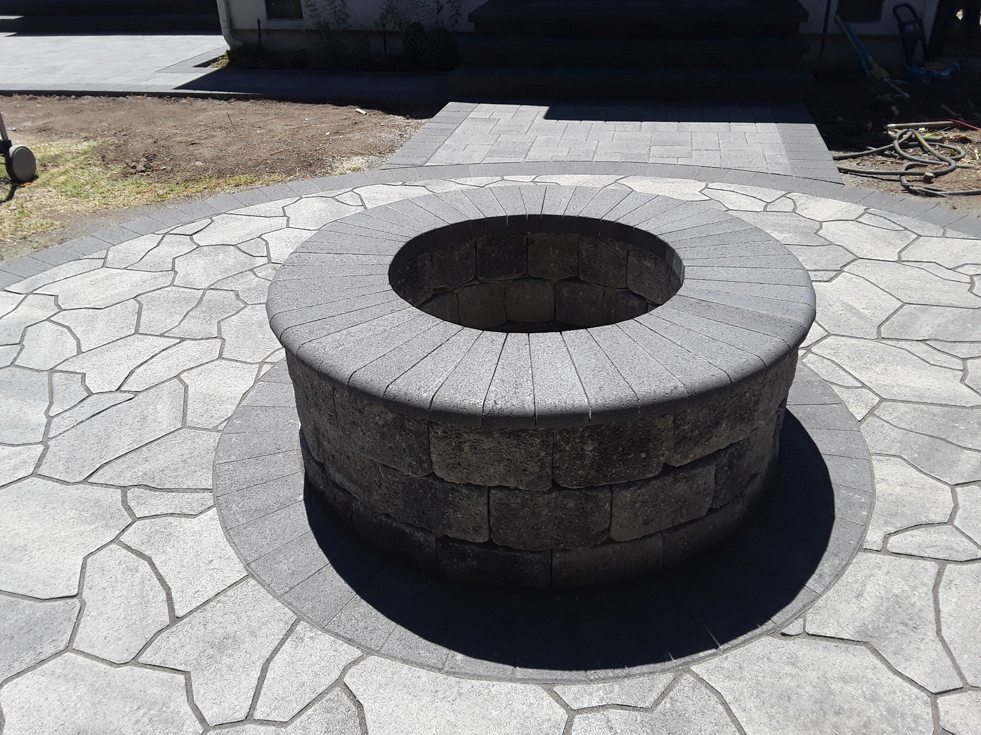 Stone firepit and flagstone backyard